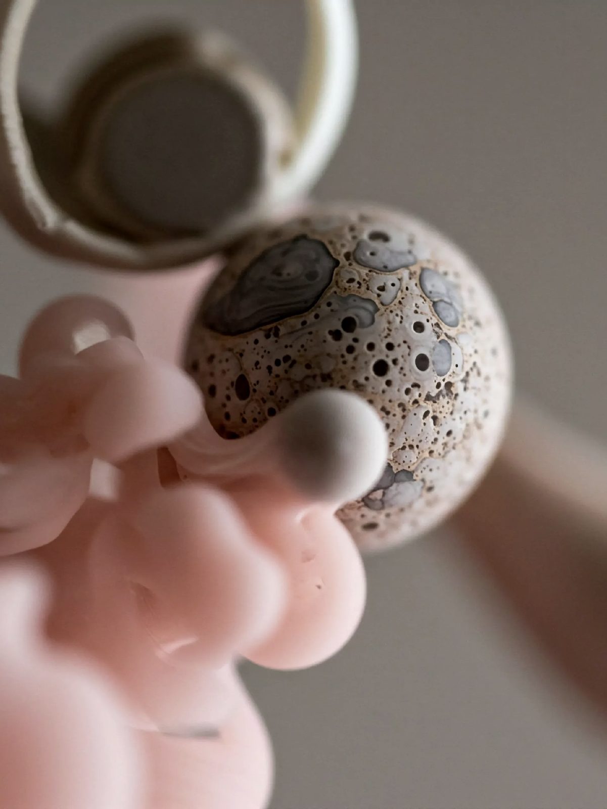 A textured stone sphere resting among pale organic forms